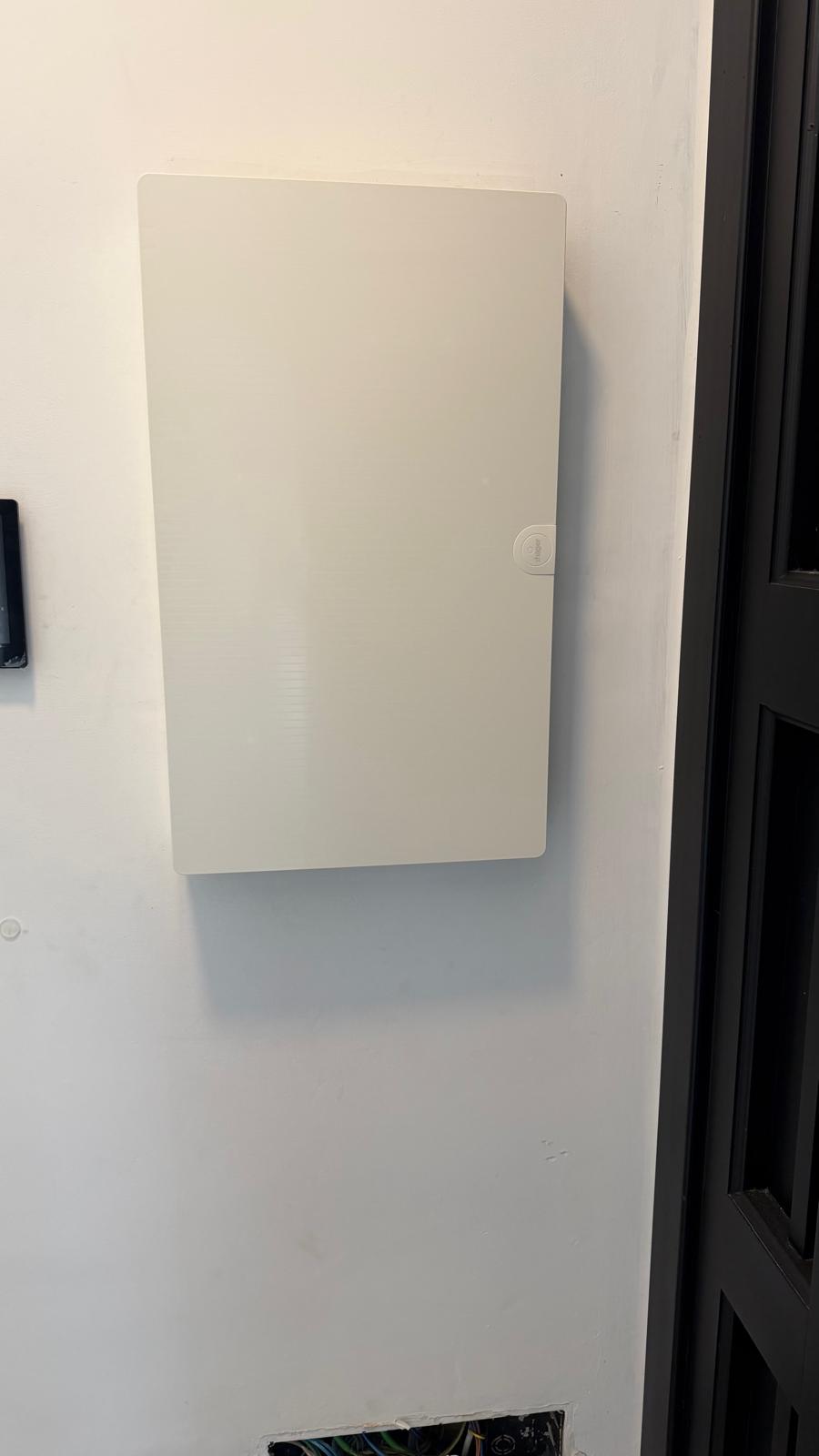Hand-over view — the finished Chint consumer unit mounted on the wall in the same position as the original, cover closed and flush with the trim, latch fitted. Internally the board is fully tested, externally it disappears into the entrance hallway exactly as the client asked. Boletín issued covering the scope of work and a digital copy of the circuit legend filed with the project documentation.