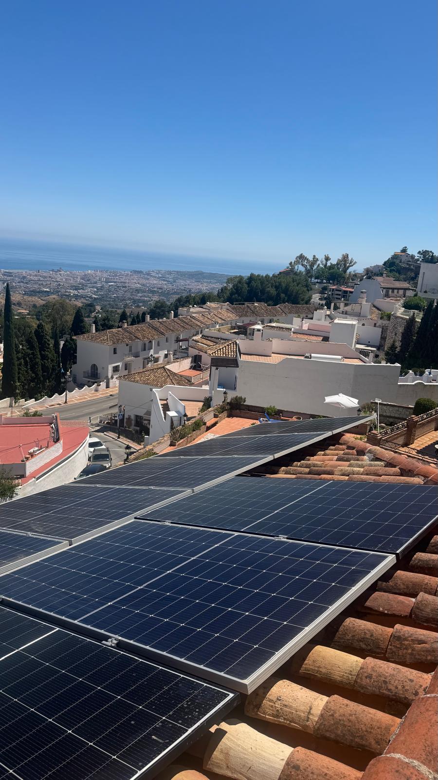 Instalación completada vista desde arriba — el conjunto completo correctamente asegurado, con los tejados tradicionales del pueblo de Mijas Pueblo abajo y la costa mediterránea en el horizonte.