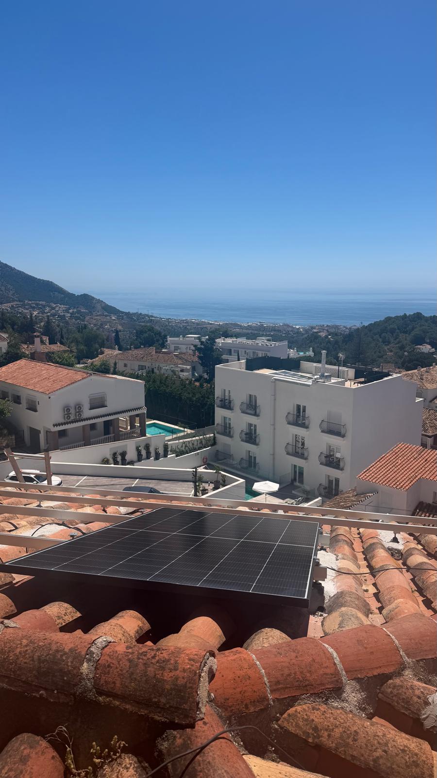 Primer panel reinstalado sobre el nuevo sistema de raíles — el Mar Mediterráneo claramente visible en el horizonte más allá de los tejados del pueblo de Mijas y la terraza de la piscina.